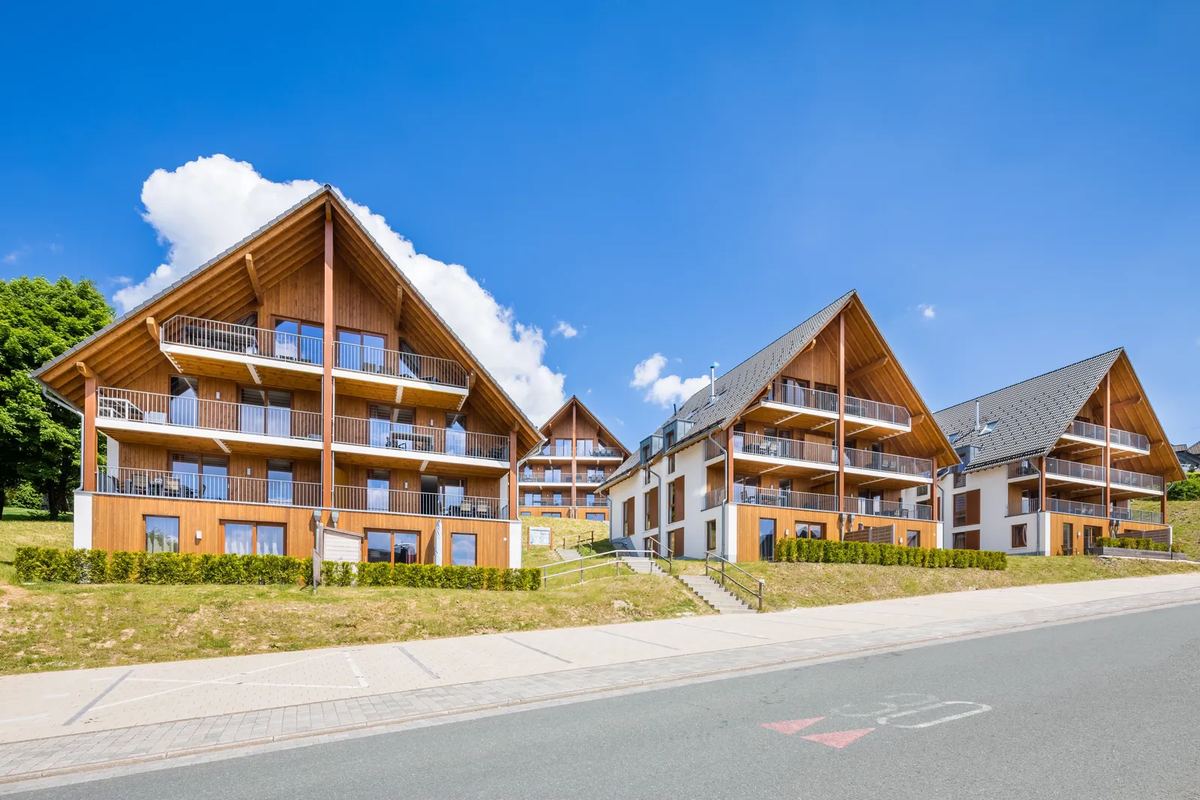Große Ferienhäuser mit Holzbalkonen an einer Straße