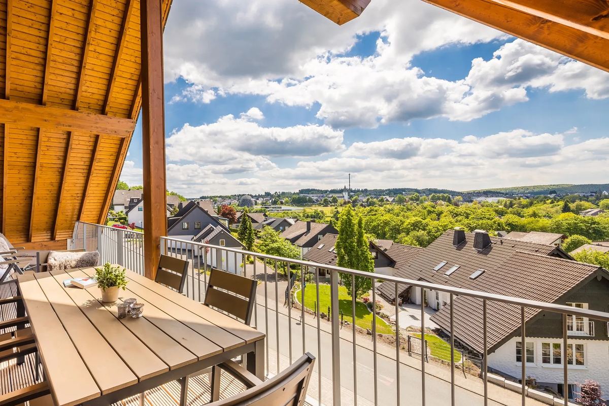 Balkon mit Esstisch und Blick über Hügel und Häuser
