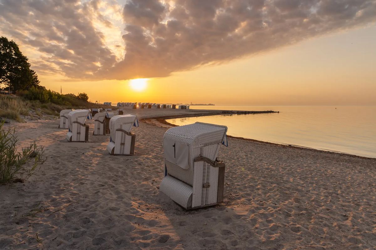 Strandkörbe am Ostseestrand bei Sonnenaufgang