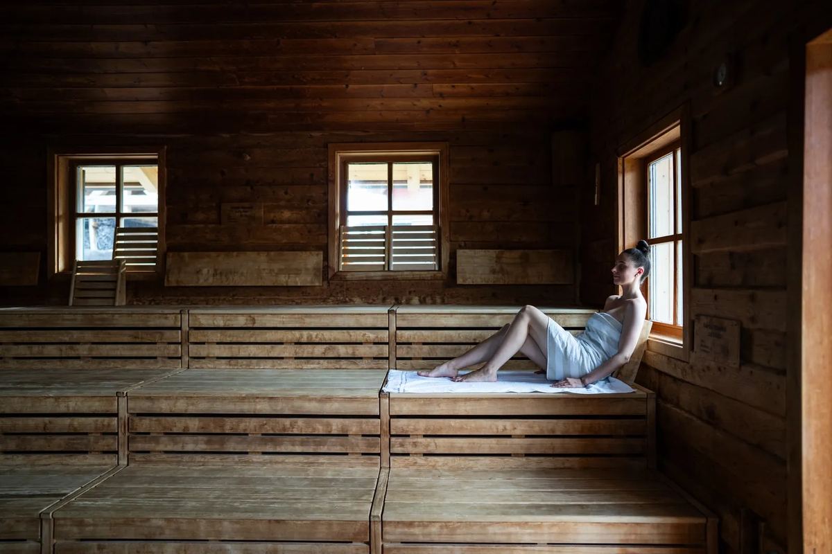 Frau entspannt in einer Holzsauna