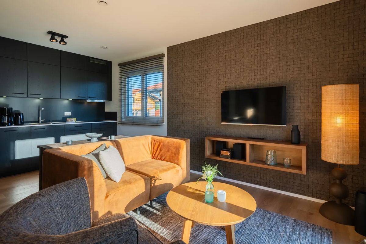 Wohnzimmer mit Ledersofa und Küche