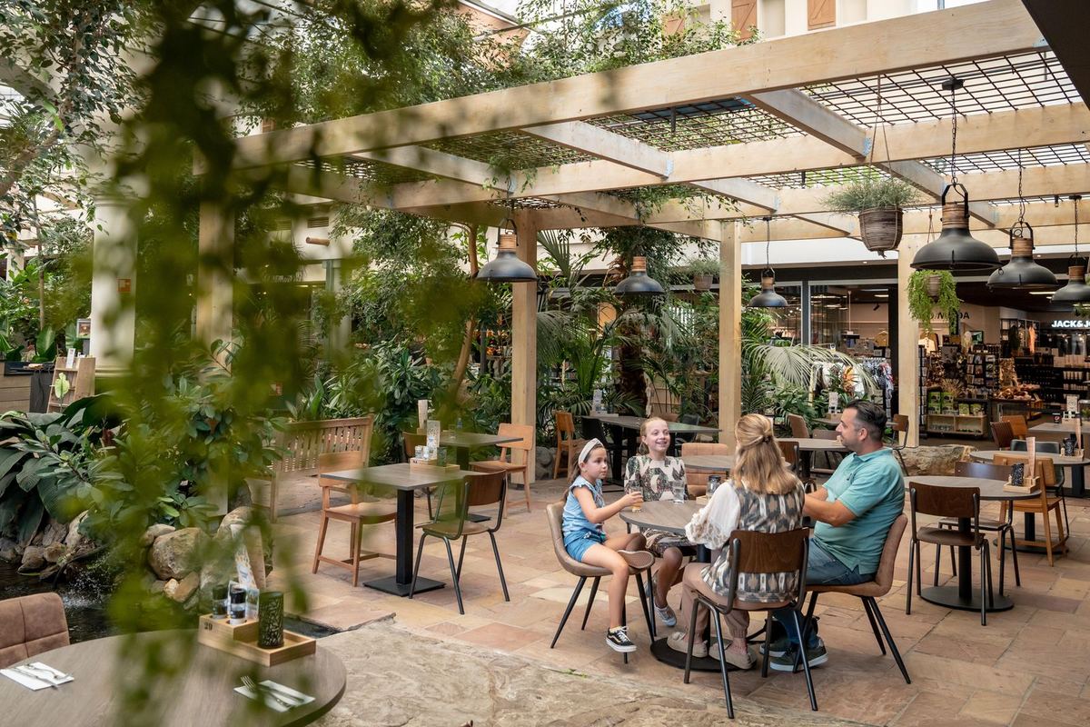 Familie auf einer begrünten Restaurantterrasse
