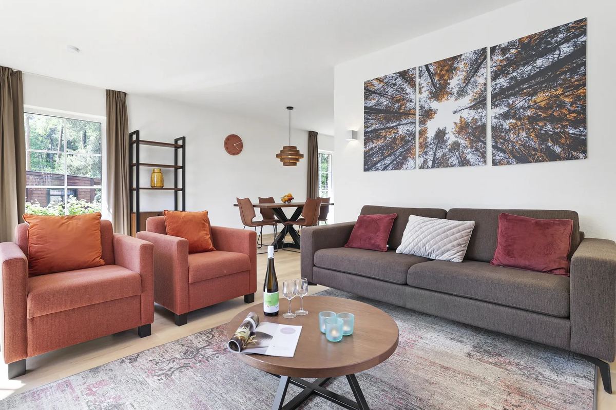 Wohnzimmer mit Sofa, Sesseln und Wandbild