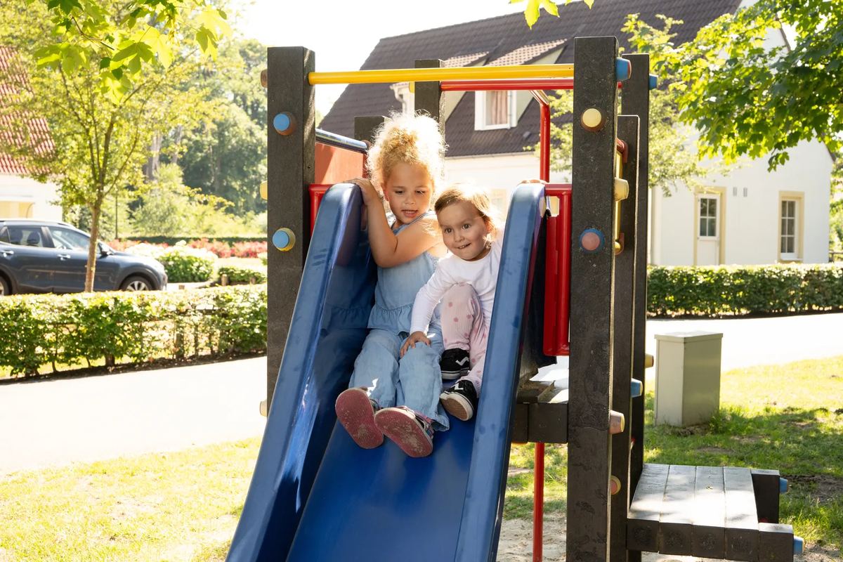 Kinder auf einer Rutsche am Spielplatz