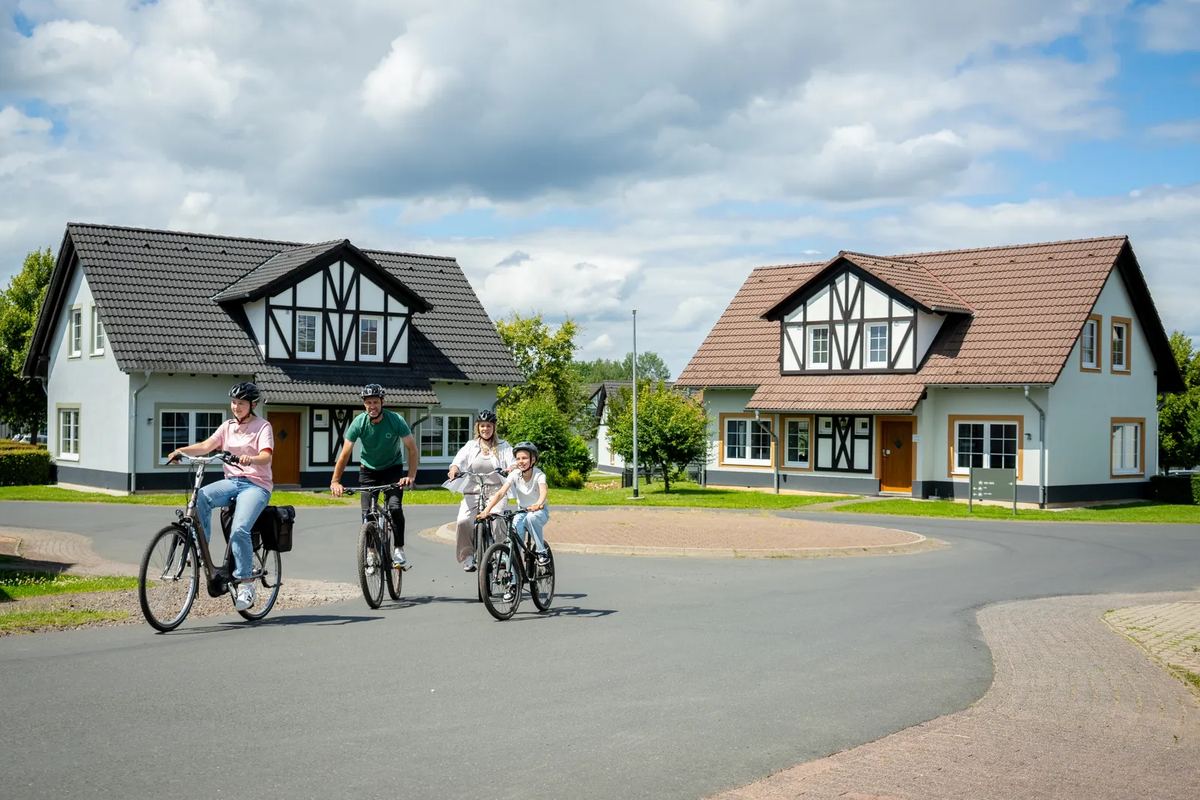 Ferienhäuser im Fachwerkstil, davor Radfahrer