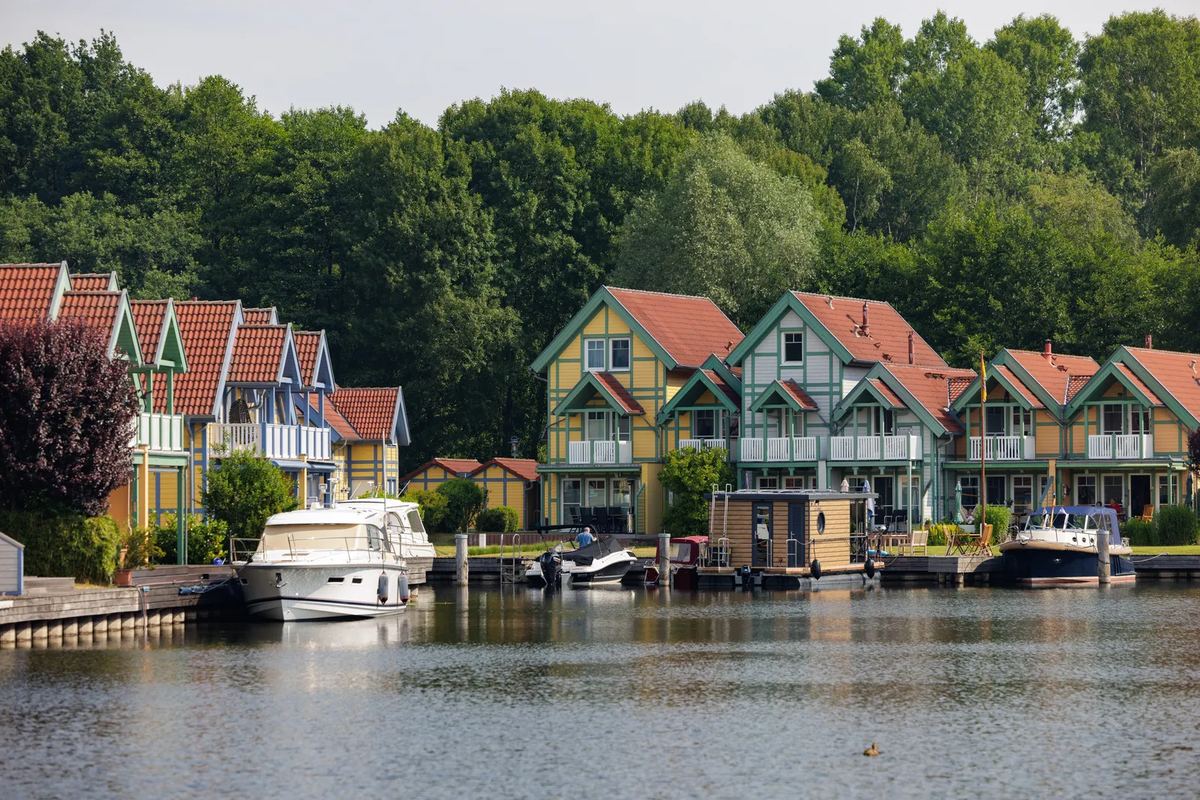 Ferienhäuser am Ufer mit Motorbooten