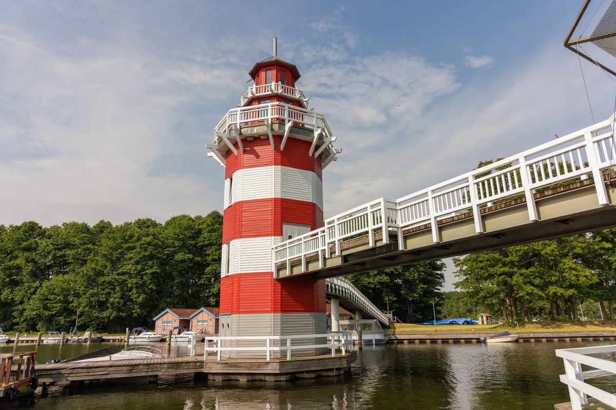 Rot-weißer Leuchtturm an einer Brücke im Hafen