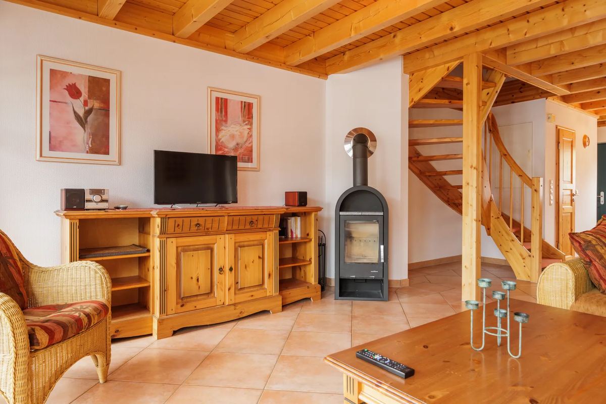 Wohnzimmer mit Kaminofen und Holztreppe