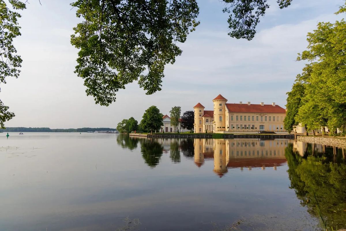 Schloss am Seeufer, das sich im Wasser spiegelt