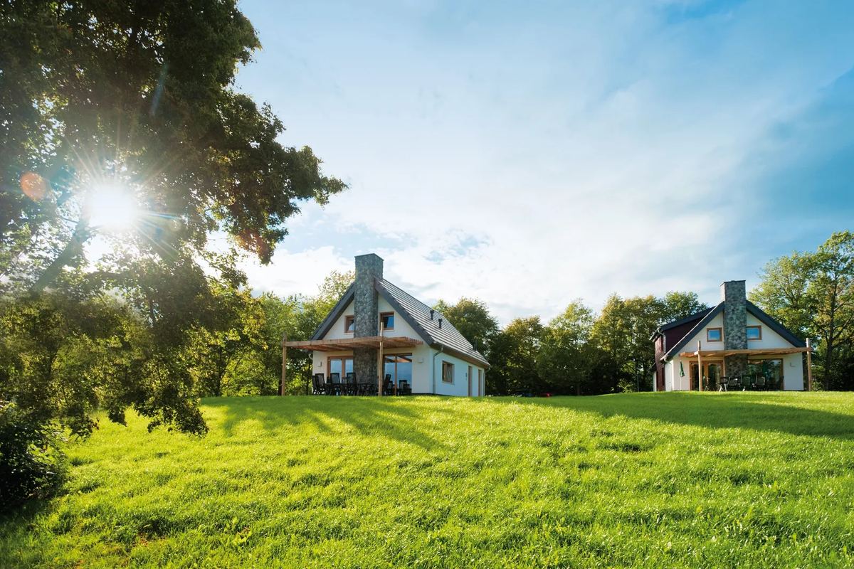 Zwei Ferienhäuser auf einer Wiese im Gegenlicht