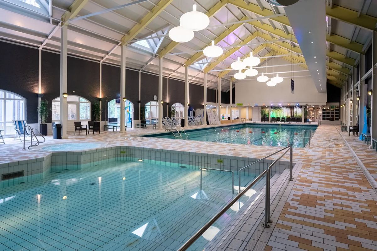 Hallenbad mit Becken unter einem Glasdach