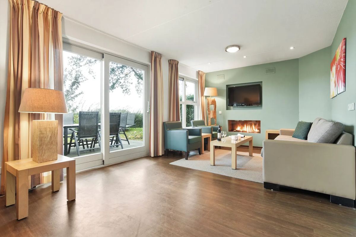 Wohnzimmer mit Kamin und Fenstertüren zur Terrasse