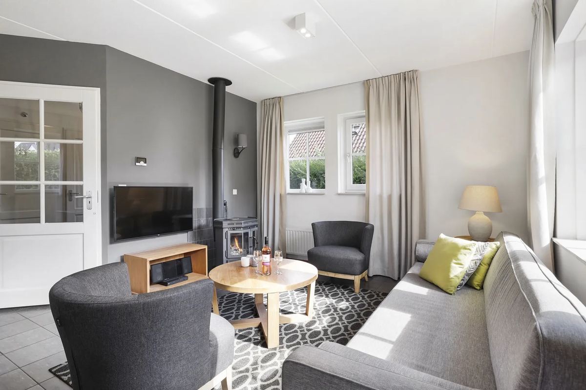 Wohnzimmer mit Ofen und Sesseln
