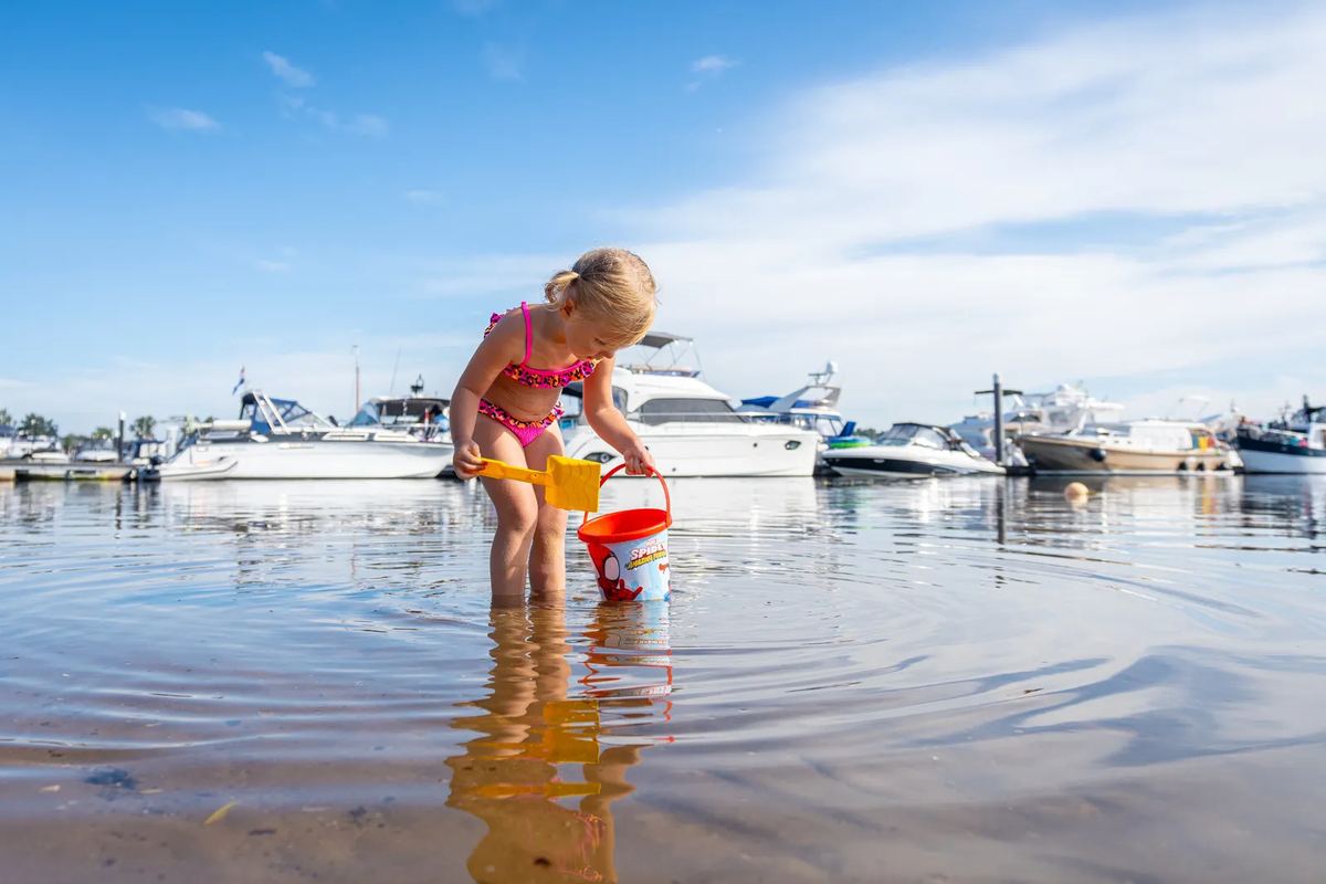 Kind spielt im flachen Wasser am Hafen