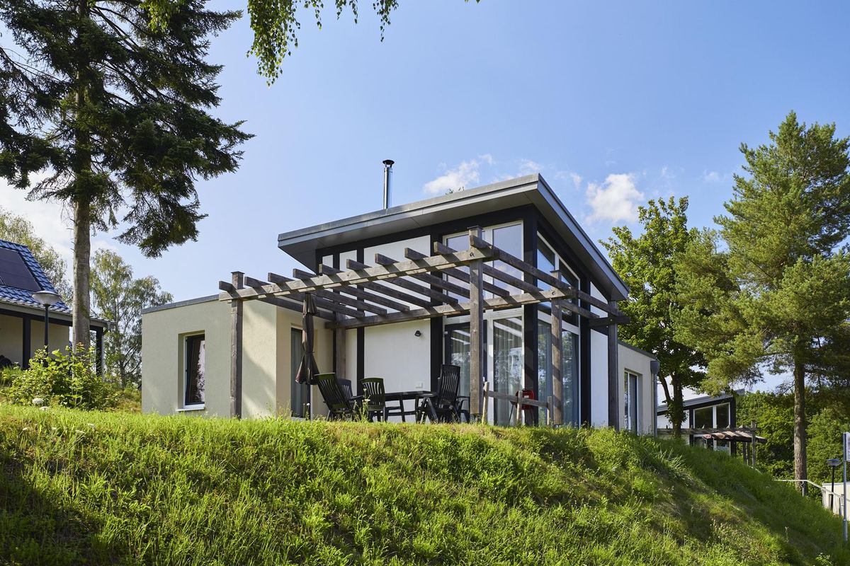 Modernes Ferienhaus mit Pergola und Rasen davor