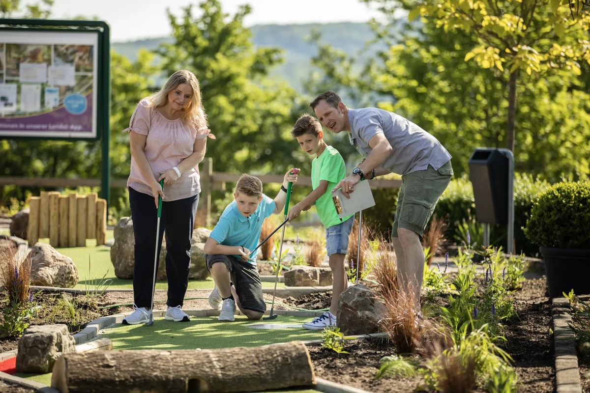 Familie spielt Minigolf