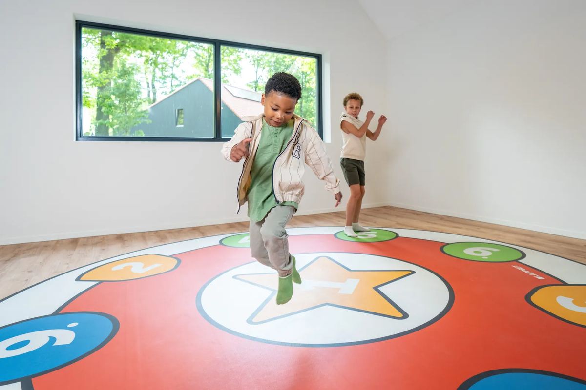 Kinder hüpfen auf einem bunten Spielboden