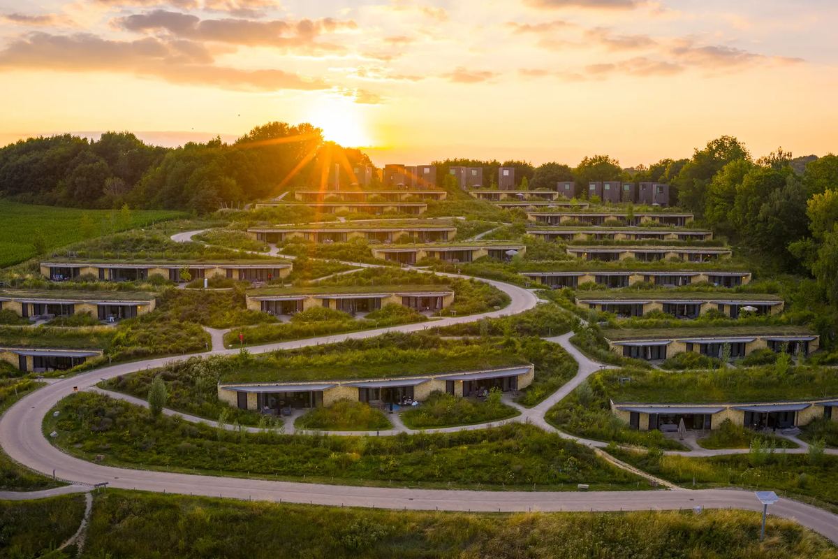 Ferienhäuser mit Gründächern am Hang bei Sonnenuntergang