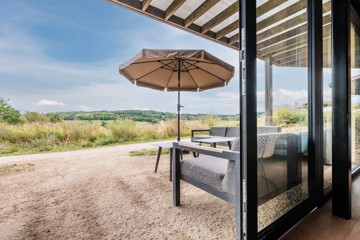 Terrasse mit Sonnenschirm und Blick ins Land