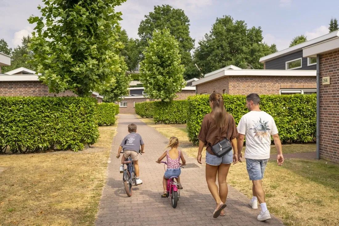 Familie mit Fahrrädern zwischen Bungalows
