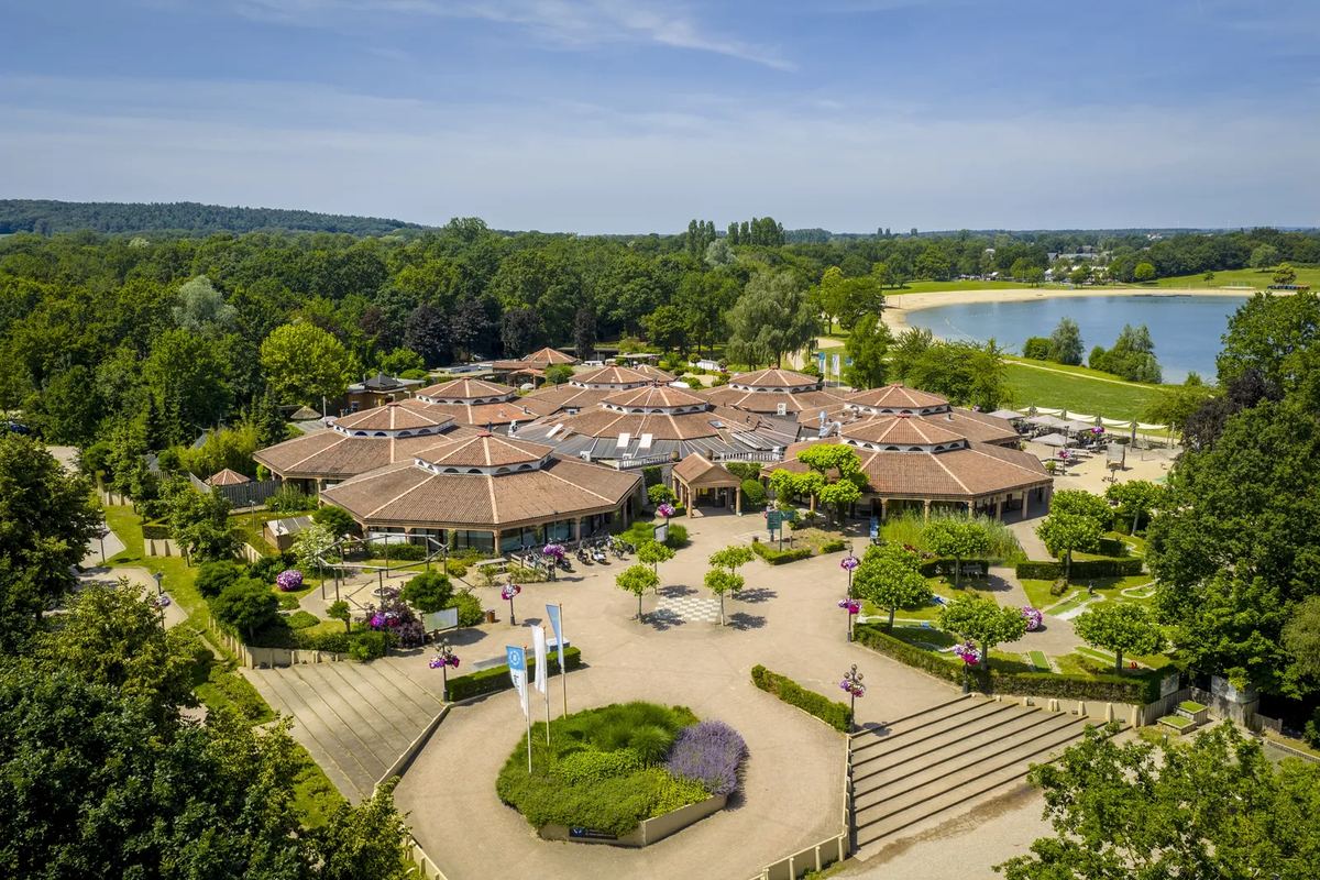 Luftbild: Zentrum mit Ferienhäusern, dahinter ein See
