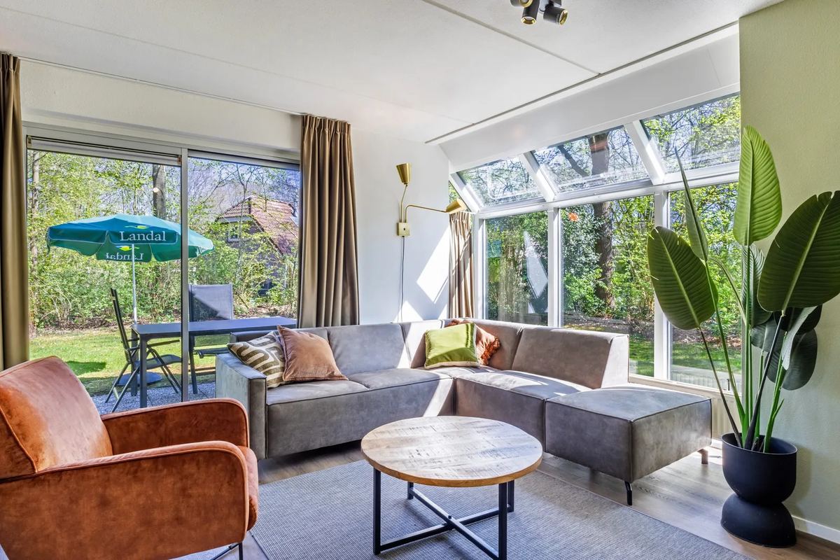 Wohnzimmer mit Ecksofa und Gartenblick