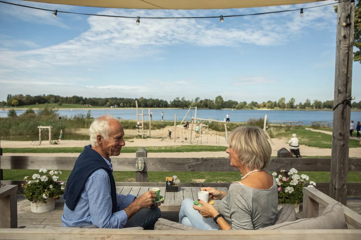 Paar auf einer Terrasse mit Blick auf den See
