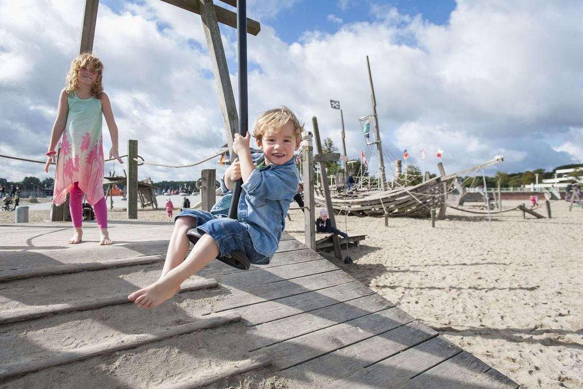 Kinder auf einer Seilbahn am Strand