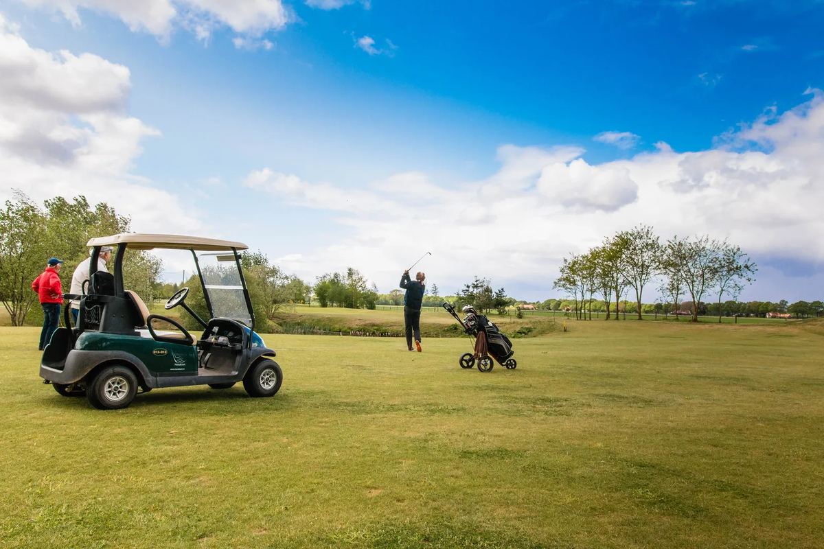 Golfer mit Golfwagen auf dem Platz