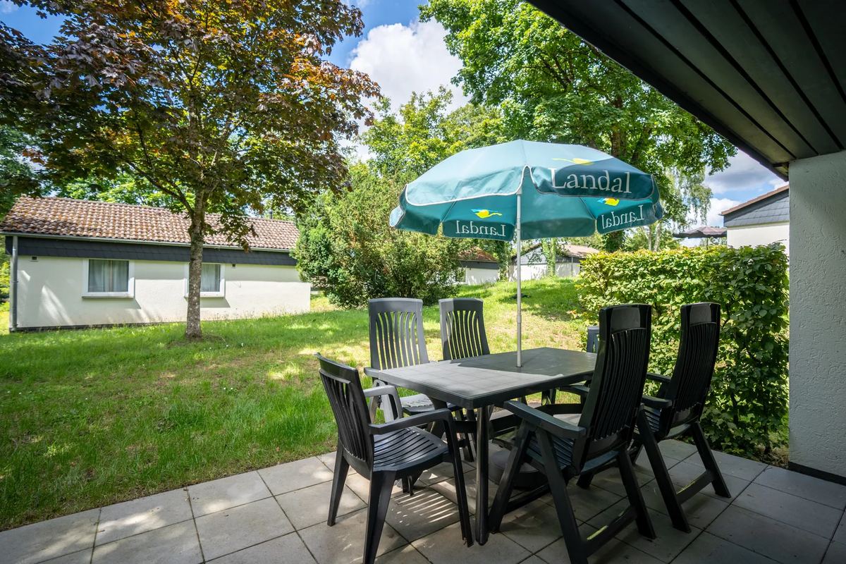 Terrasse mit Tisch und Stühlen vor einem Ferienhaus