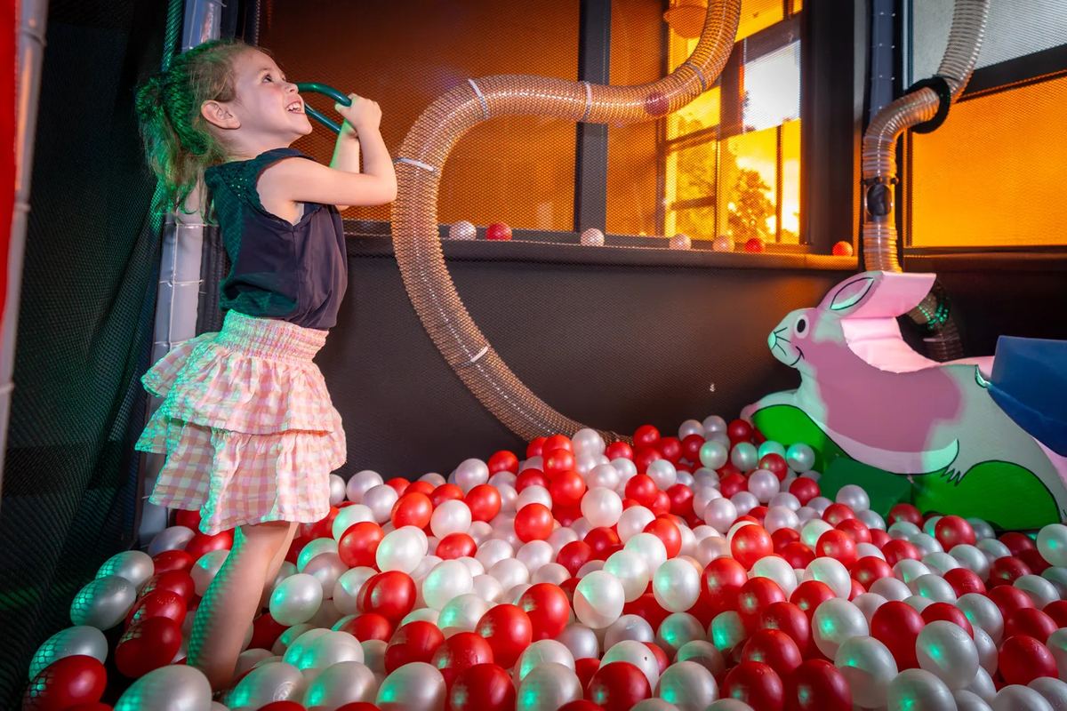Mädchen im Bällebad eines Indoor-Spielplatzes