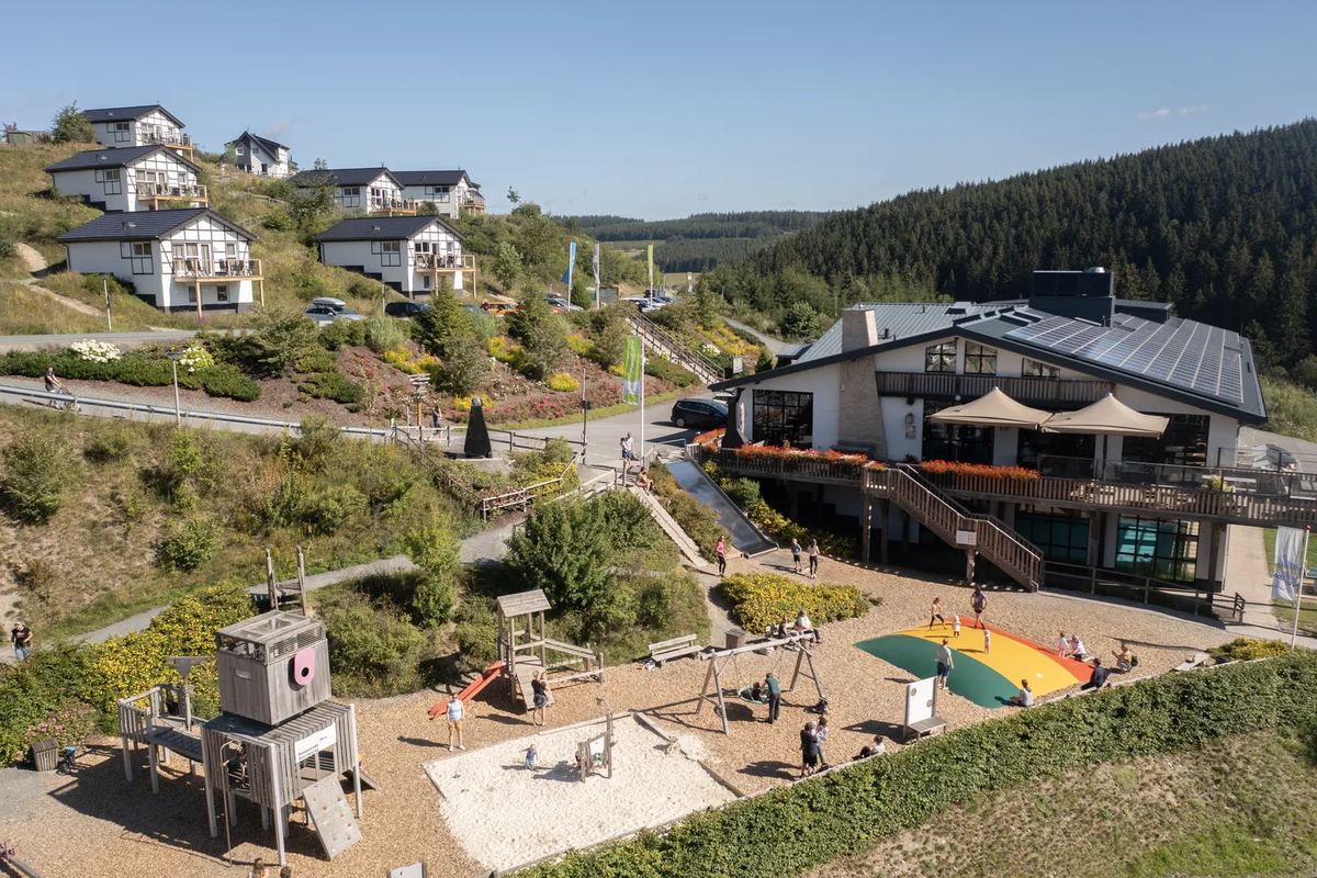 Luftbild: Zentralgebäude mit Spielplatz am Hang
