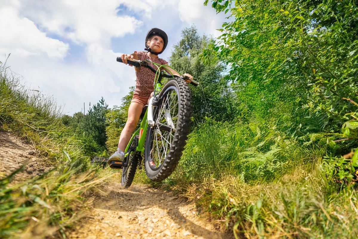 Kind springt mit dem Mountainbike