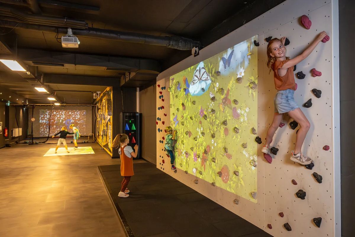 Mädchen an einer Kletterwand in einer Halle